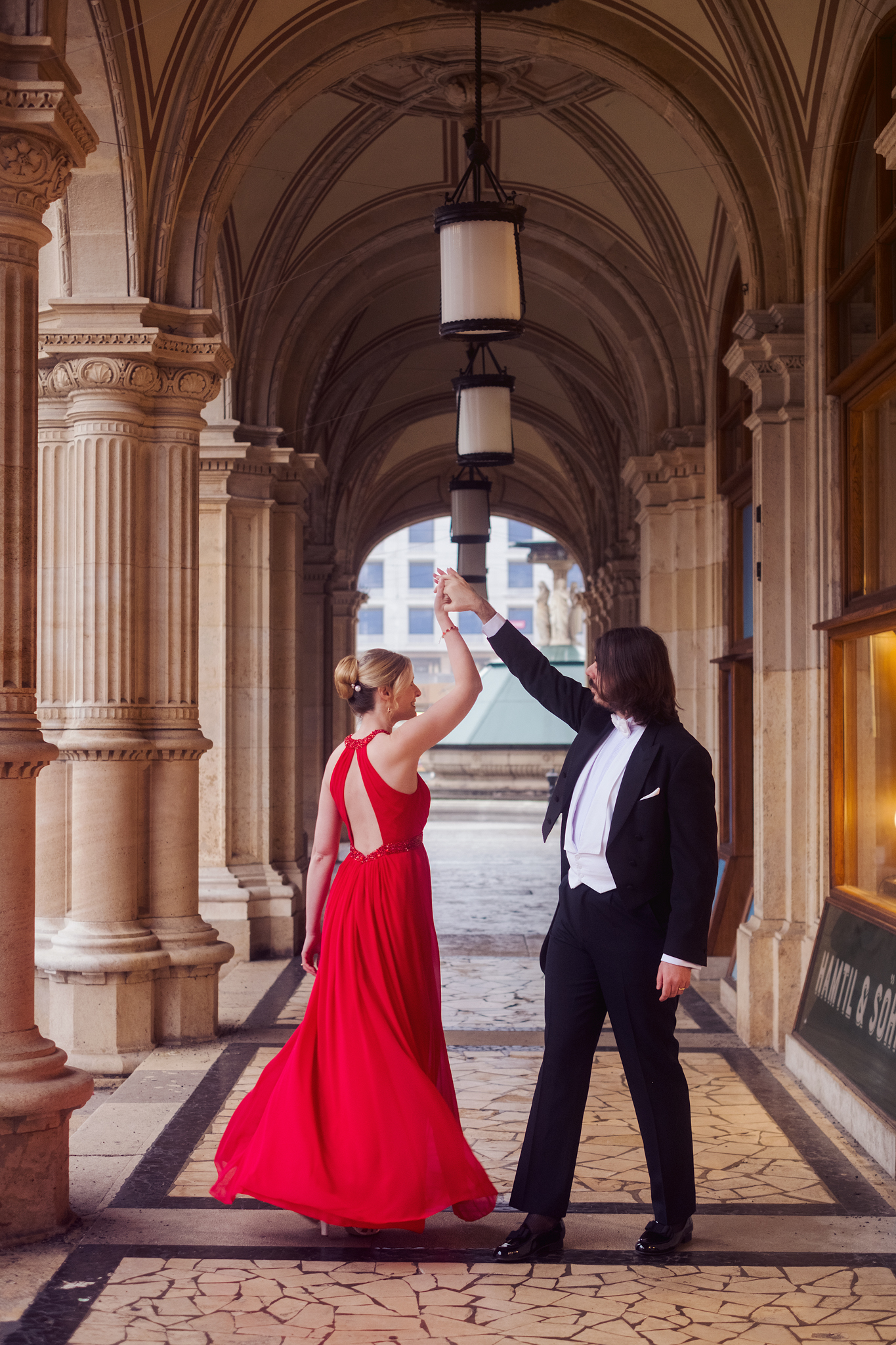 veinna couple photoshoot with a long red dress by the opera arches 